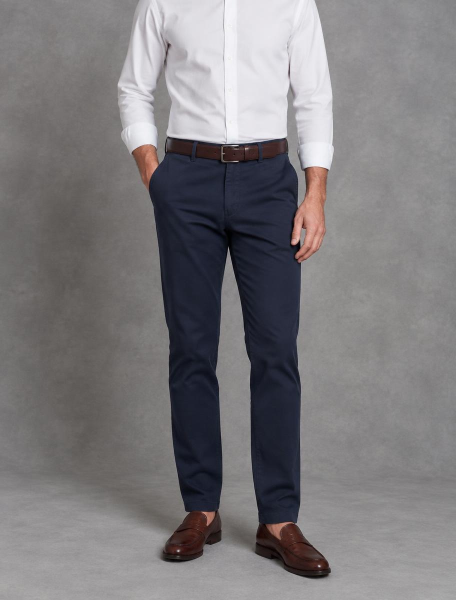 Navy cotton chinos worn with a white shirt, brown belt and leather loafers