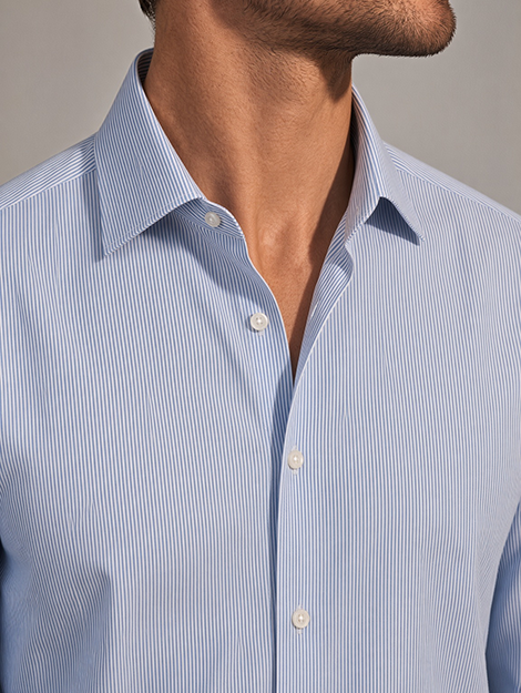 Close-up of a man wearing a fine blue and white striped shirt with a spread collar