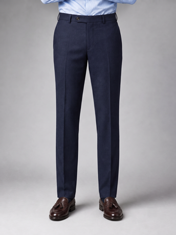 Navy tailored wool trousers worn with a light blue shirt and brown tassel loafers
